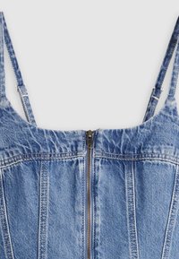 Μπλε τζιν αμάνικη μπλούζα με ρυθμιζόμενους λεπτούς ιμάντες και κεντρικό μεταλλικό φερμουάρ στο μπροστινό μέρος.