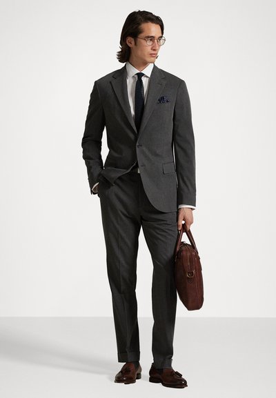 Hallhallide mustriga helesinine kostüüm, mille juurde on pandud valge särgiga ja mereväe sinise lipsuga. Ilus pruun nahkjalats ja kott täiustavad välimust.