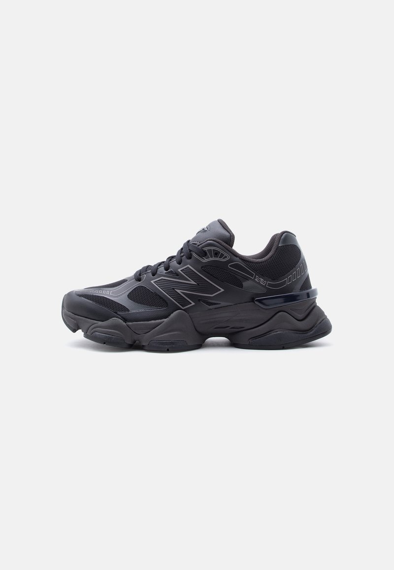 Baskets de sport noires avec semelle épaisse, dessus en mesh et synthétique, fermeture à lacets et logo de la marque sur le côté.
