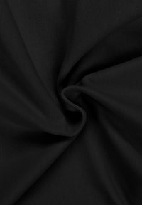 Tissu noir à texture fine et tissée, rassemblé en un pli spirale doux au centre sur un fond uni.