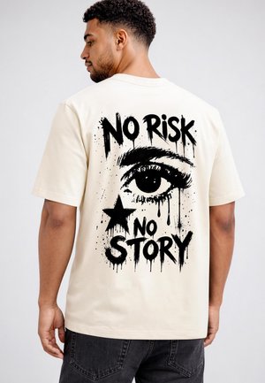 Man wearing off-white t-shirt with black graphic of an eye, a star, and text saying "NO RISK NO STORY" on the back.