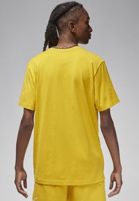 T-shirt di cotone giallo con maniche corte e una vestibilità comoda, caratterizzato da un design semplice e un collo rotondo. Tessuto liscio con cuciture visibili.
