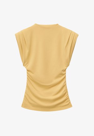 Beżowa bluzka bez rękawów z marszczonymi bokami i okrągłym dekoltem, prezentowana na białym tle.