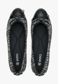 Czarno-białe baletki z tweedu z błyszczącą czarną czubkiem, dekoracyjną kokardką i wbudowaną wkładką z logo; teksturowana cholewka i miękka wyściółka wewnętrzna.