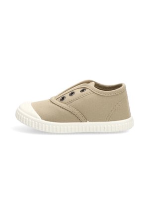 Zapatilla beige de lona sin cordones, con puntera y suela de goma blanca, que presenta tres ojales metálicos negros en el lateral.