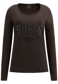 Langärmliges braunes Baumwoll-T-Shirt mit einem glitzernden schwarzen "GUESS"-Logo, rundem Ausschnitt und weichem Material.