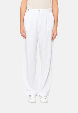 White linen wide-leg pants with a high waist, featuring front pleats and decorative button accents. Paired with white sneakers.
