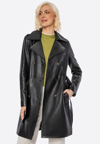 Cappotto doppiopetto in pelle nera con ampio colletto e bottoni dorati, dotato di tasche laterali e una superficie liscia e lucida.