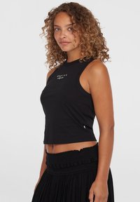 Svart ärmlös crop top i bomull med rund halsringning och logotryck på bröstet, tillsammans med en textured svart högmidjad kjol.