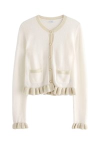 Cream cardigan with a button front, textured fabric, ruffled bottom edges, and two front pockets. Accents in a lighter shade.