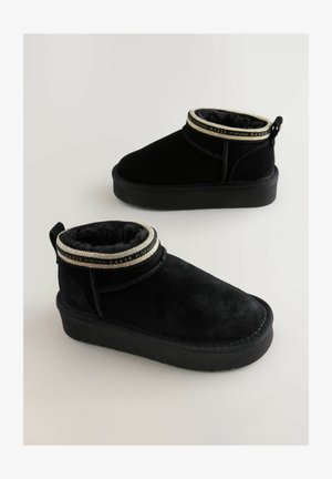 Melni zamšādas potītes zābaki ar neīstu kažokādu iekšpusē un dekoratīvu zeltītu aproci. Bieza melna gumijas zole.