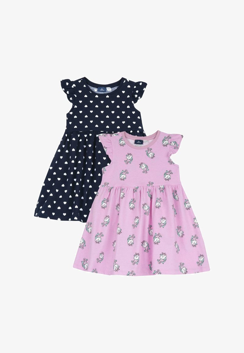 Dvoje dětských šatů: jedny námořnické modré s bílým vzorem srdíček a volánkovými rukávy, druhé růžové s potiskem jednorožců a odpovídajícím volánkovým detailem.
