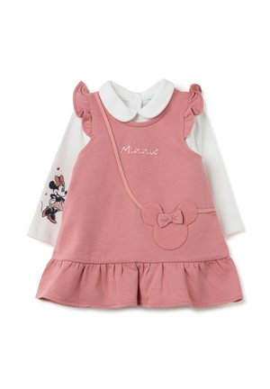 Abito rosa senza maniche con spalline a frangia, caratterizzato da un colletto rotondo e un fiocco decorativo. Sopra, è abbinata una camicia bianca a maniche lunghe.
