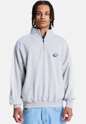 Szara bluza rozpinana na suwak z wysokim kołnierzem, luźnym krojem i białymi panelami po bokach. Posiada małe haftowane logo na piersi.