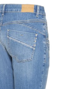 Jeans in denim azzurro chiaro con vita a metà, dotati di una targhetta del marchio in pelle, una tasca posteriore singola e borchie decorative argentate sul bordo della tasca.