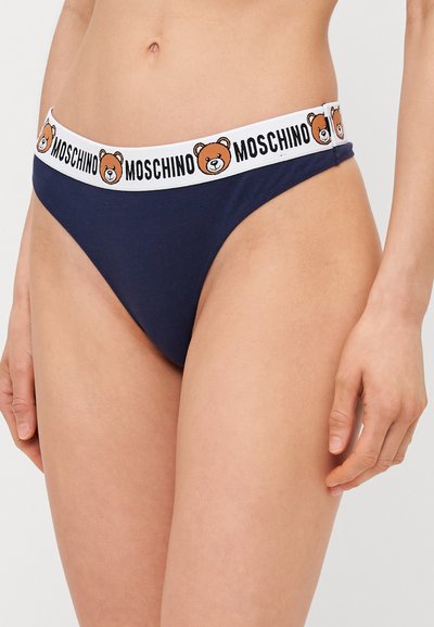 Granatowe stringi z białym elastycznym pasem w talie z logo Moschino i motywem niedźwiedzia; gładki materiał o dopasowanym kroju.