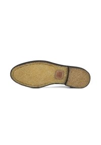 Semelle de chaussure avec une couche extérieure texturée et sombre et un intérieur léger et duveteux. Comprend un petit patch rectangulaire avec un logo près du talon.