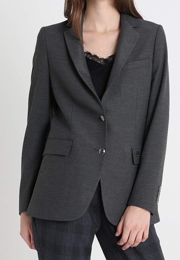 Blazer gris foncé à coupe cintrée, design à simple boutonnage, deux poches frontales et texture subtile. Comprend des boutons noirs et un revers cranté.