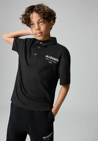 Juodas polo marškinėliai su trimis mygtukais, priekyje su baltu "ALLSAINTS" logotipu ir tekstu. Lygus audinys, trumpomis rankovėmis, klasikinio kirpimo.