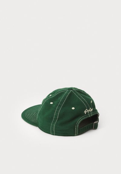 Boné de basebol verde em algodão com aba curva, costuras brancas, orifícios de ventilação e fecho de tiras com uma fivela de metal.