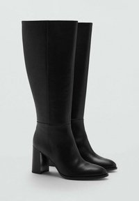 Botas negras hasta la rodilla de cuero suave con punta cuadrada y tacón grueso. Diseño minimalista y superficie superior sin costuras.