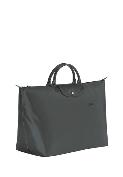 Gray nylon tote bag with dual top handles, a zip closure, and a textured leather flap. Features minimal branding on the front.