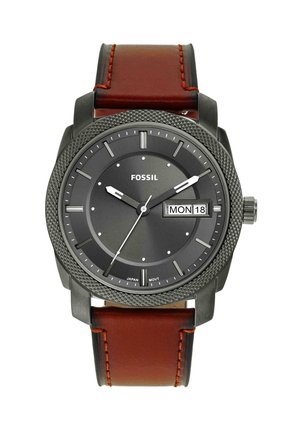 Round black Fossil wristwatch with textured bezel, brown leather strap, white hour markers, and day-date display showing Monday 18.