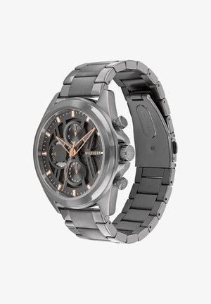 Montre-bracelet Tommy Hilfiger en acier inoxydable avec cadran noir, index des heures en or rose, trois sous-cadrans et bracelet à maillons en métal.
