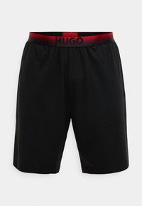 Pantalones cortos negros de material suave con una cintura elástica que presenta un degradado rojo y la marca "HUGO" en negro. Diseño sencillo y de corte recto.