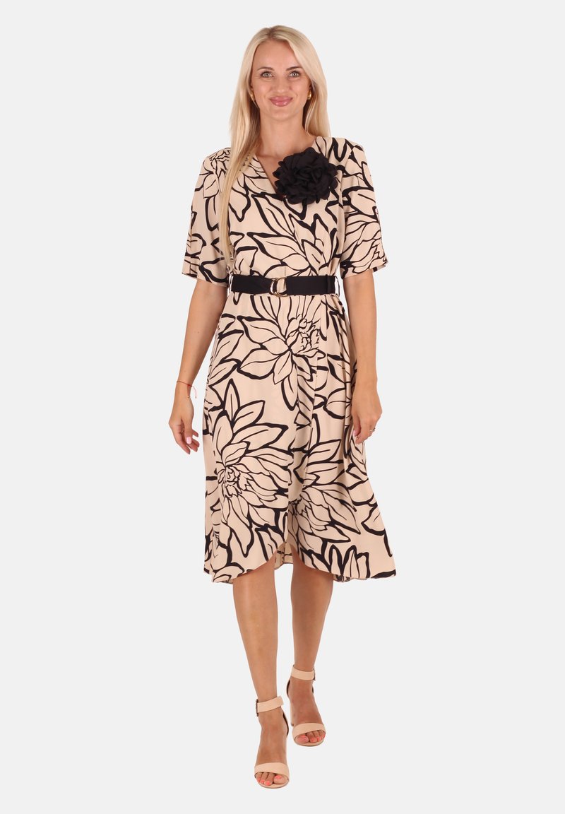 Beige Midi-Kleid mit floralen Muster und schwarzen Konturen. Verfügt über einen Gürtel und einen Stoffblumenakzent auf der Schulter. Weiches, fließendes Material.