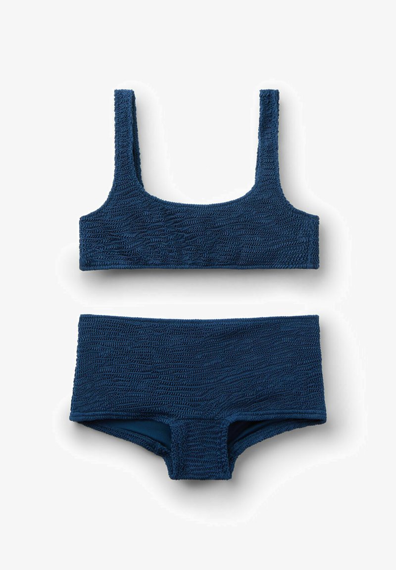 Maillot de bain deux pièces bleu marine texturé avec un haut à encolure carrée et un bas taille haute, posé à plat sur un fond blanc.