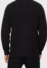 Pull noir en maille avec un motif texturé, des poignets et un ourlet côtelés. Présente un col rond et une coupe décontractée pour plus de confort.