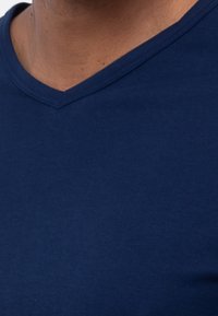 Navyblaue Baumwoll-T-Shirt mit V-Ausschnitt und kurzen Ärmeln, glatter Textur und tailliertem Design. Keine sichtbaren Muster oder Hardware-Akzente.