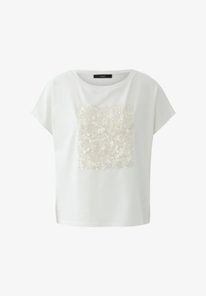 Blouse blanche à manches courtes avec un col rond et un groupe de sequins blancs en forme carrée au centre avant.