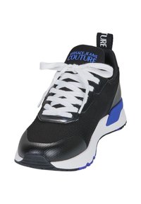 Baskets en mesh noires avec lacets blancs, accents argentés et détail bleu au talon. Présente un col rembourré et une semelle en caoutchouc texturé. Logo de la marque sur la languette.