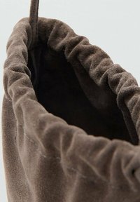 Borsa in suede marrone con bordo superiore arricciato, caratterizzata da una texture morbida e una chiusura con cordoncino. L'interno è scuro e liscio.