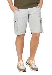 Light gray cargo shorts with side pockets and a textured pattern, paired with multi-colored sneakers featuring orange accents.