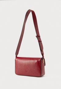 Κόκκινη δερμάτινη τσάντα χιαστί με υφή, ρυθμιζόμενο λουρί, εξαρτήματα σε χρυσό τόνο και ορθογώνιο σχήμα.