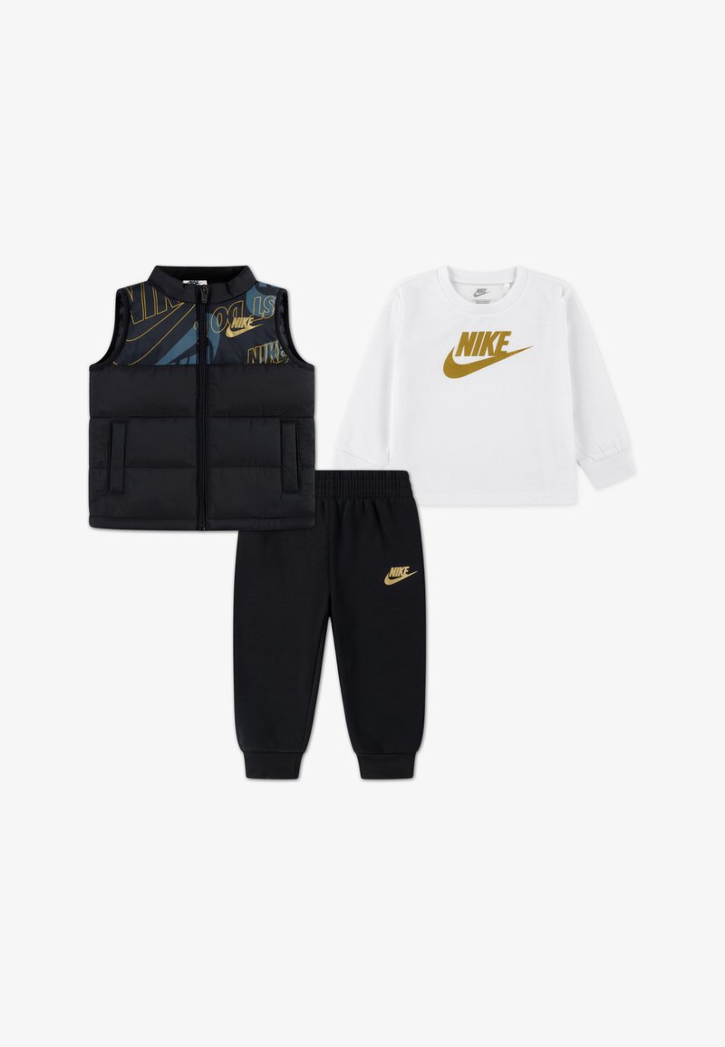 Nike Kinderoutfit mit einer schwarzen Steppweste mit blauen Akzenten, einem weißen Langarmshirt und einer schwarzen Jogginghose mit goldenen Logos.