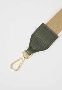 Cintura in pelle verde con hardware dorato, caratterizzata da una superficie texturizzata e da una sezione in tela beige con strisce bianche.