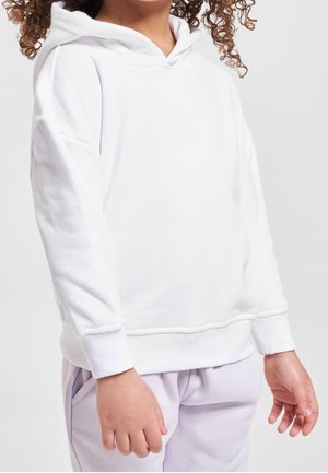 Biała bluza z kapturem o miękkiej fakturze, wyposażona w kaptur ze sznurkiem, ściągacze na rękawach i dole; zestawiona z jasnofioletowymi spodniami dresowymi.
