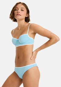 Blue bikini set with textured fabric, featuring a fitted top and low-rise bottom, both outlined in white. Adjustable thin straps.