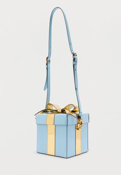 Τσάντα χειρός τετράγωνου σχήματος σε ανοιχτό γαλάζιο χρώμα με μεταλλικές χρυσές λεπτομέρειες κορδέλας και φιόγκο στην κορυφή, με ρυθμιζόμενο ιμάντα ώμου.