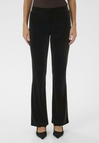 Pantalons noirs évasés en velours doux avec une texture lisse et un éclat subtil. Dotés d'une taille ajustée et d'une longueur standard.