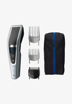 Tagliacapelli cordless in argento e nero, con impugnatura texturizzata, tre pettini regolabili e una borsa nera con zip e accenti blu.