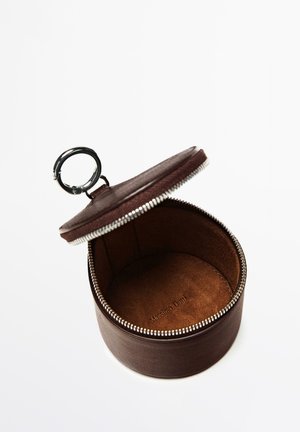 Ronde bruine leren etui met rits, zilveren ring en de tekst "Massimo Dutti" erin gegraveerd, geopend afgebeeld tegen een witte achtergrond.