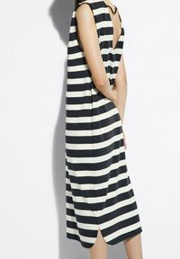 Zwart-wit gestreepte mouwloze jurk met een V-vormige rug, knielang, met een zijsplit en een zachte stofstructuur. Eenvoudige, ontspannen pasvorm.