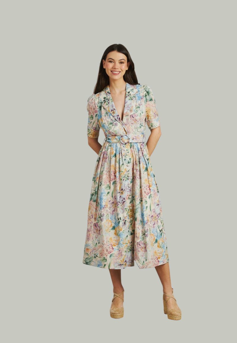 Abito midi con stampa floreale in tessuto leggero, dotato di scollatura a V, maniche corte, vita con cintura e gonna svasata. I colori includono rosa, verde e giallo.