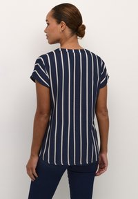 Blusa de rayas marinas con mangas cortas, con rayas verticales en blanco y azul claro. Tejido suave y ligero con un corte recto.