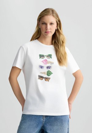 White cotton t-shirt featuring a graphic of five colorful sunglasses with various patterns. Short sleeves and a round neck design.